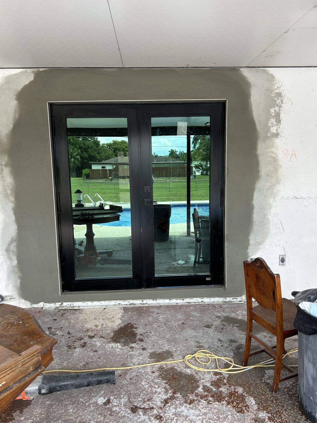 Fresh stucco rebuilt and blended around a newly installed exterior door opening, South Florida